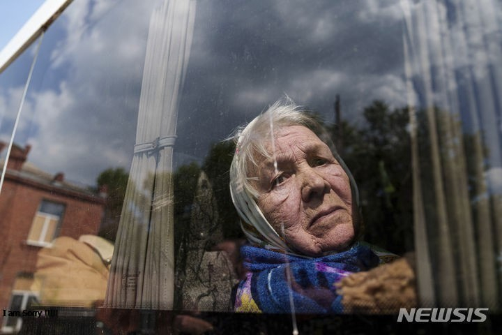 12일 우크라이나 하르키우주 보우찬스크 마을에서 피란길에 오른 류드밀라(85) 할머니가 집을 떠나기 아쉬운 듯 버스 창밖을 내다보고 있다.