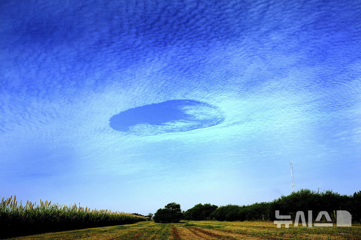 22일(현지시각) 미 텍사스주 에딘버그 북서쪽 하늘에 '폴스트리크 홀'(fallstreak hole)이 보인다. 폴스트리크 홀 현상은 구름이 비행기나 외부 충격으로 얼음으로 바뀌면서 그 무게를 이기지 못하고 떨어져 구멍이 뚫린 것처럼 보이는 현상이다. 뉴시스